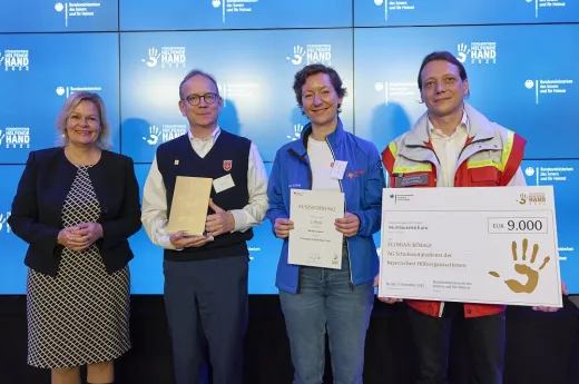 Preisverleihung Helfende Hand 2022 in Berlin Bundesministerin Nancy Faeser überreicht eine Urkunde an zwei Vertreter und eine Vertreterin der ARGE Schulsanitätsdienst