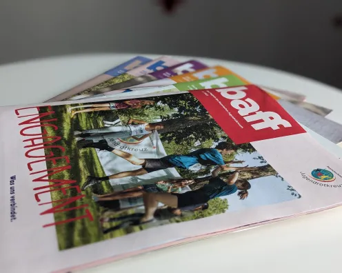 Das Bild zeigt mehrere Ausgaben des JRK-Mitgliedermagazins "baff".