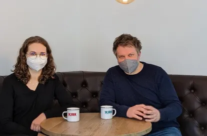 Das Bild zeigt Bildungsreferentin Pia und Geschäftsführer Jörg bei einer Tasse Kaffee am Tisch