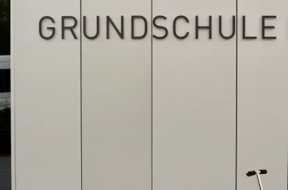 Eine graue Außenwand mit dem Schriftzug Grundschule