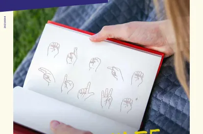 Das Cover der baff-Ausgabe 3-2023 zeigt eine Person, die ein aufgeschlagenes Buch hält, in dem die Worte "Erste Hilfe" im Fingeralphabet geschreiben steht.
