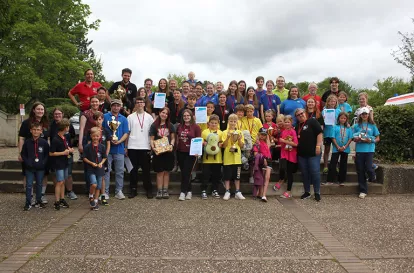 Das Bild ziegt eien Gruppe von Kindern, Jugendlichen und jungen erwachsenen, die sich für ein Gruppenfoto auf einer kleinen Treppe aufgestellt haben. Sie sind die tielhemnden des JRK-Bezirkswettbewerbs in Ober- und Mittelfranken.