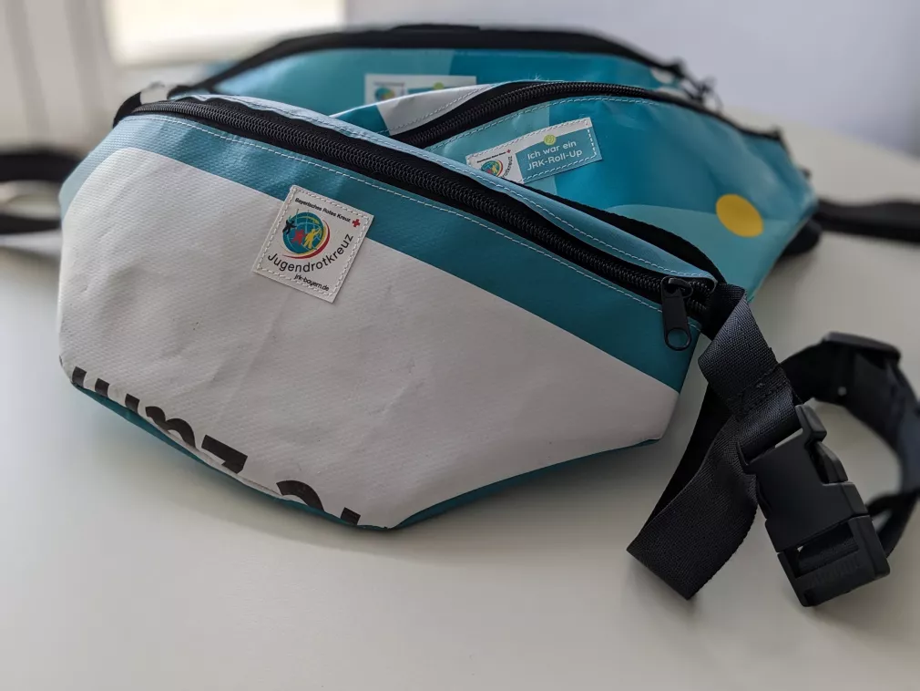 Das Bild zeigt drei Hip-Bags aus dem Upcycling-Sortiment des Bayerischen Jugendrotkreuzes.